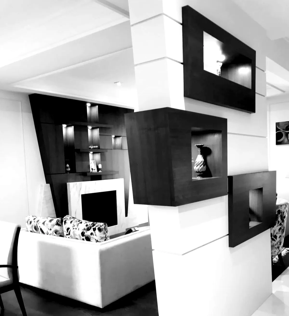 Black and white living room with floating dark wood niche boxes on a white pier