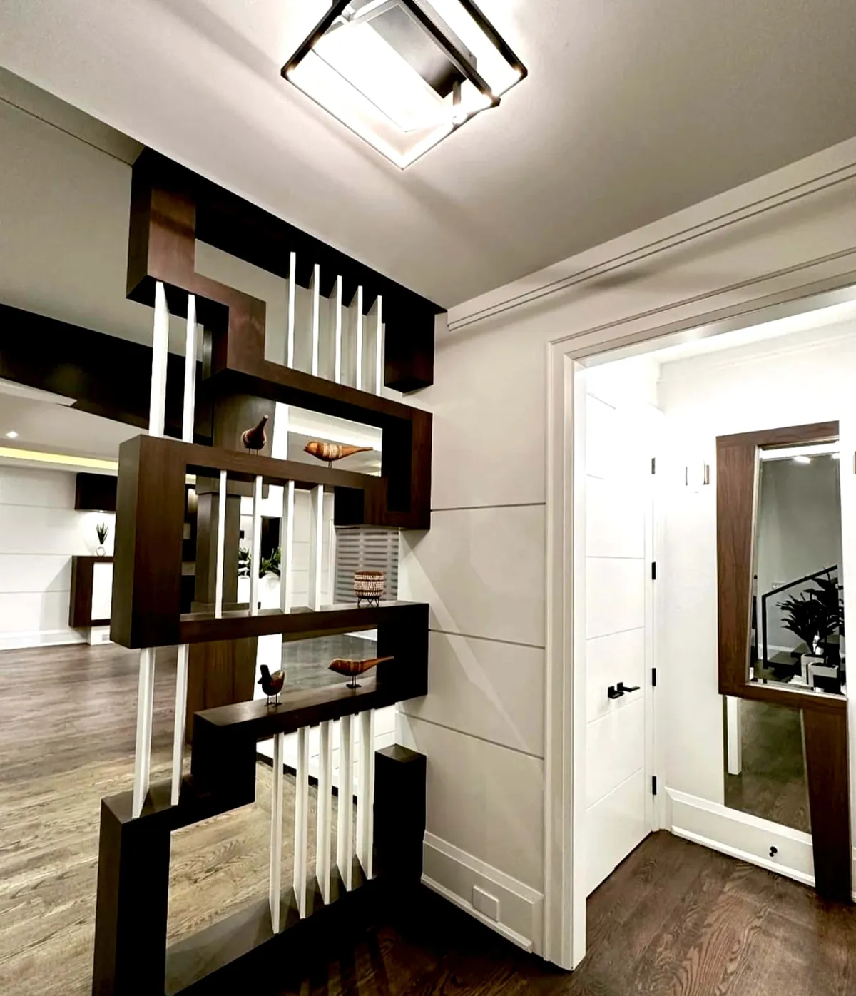 Walnut partition with white slats and a matching mirror frame beside a door