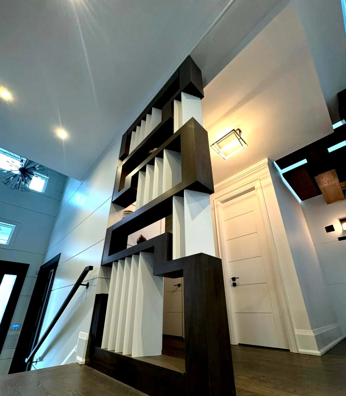 Stacked dark wood frame with white vertical slats dividing a hallway