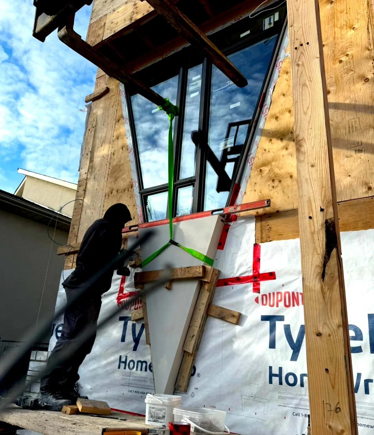 Workers fitting a precast piece against a wall covered in Tyvek HomeWrap